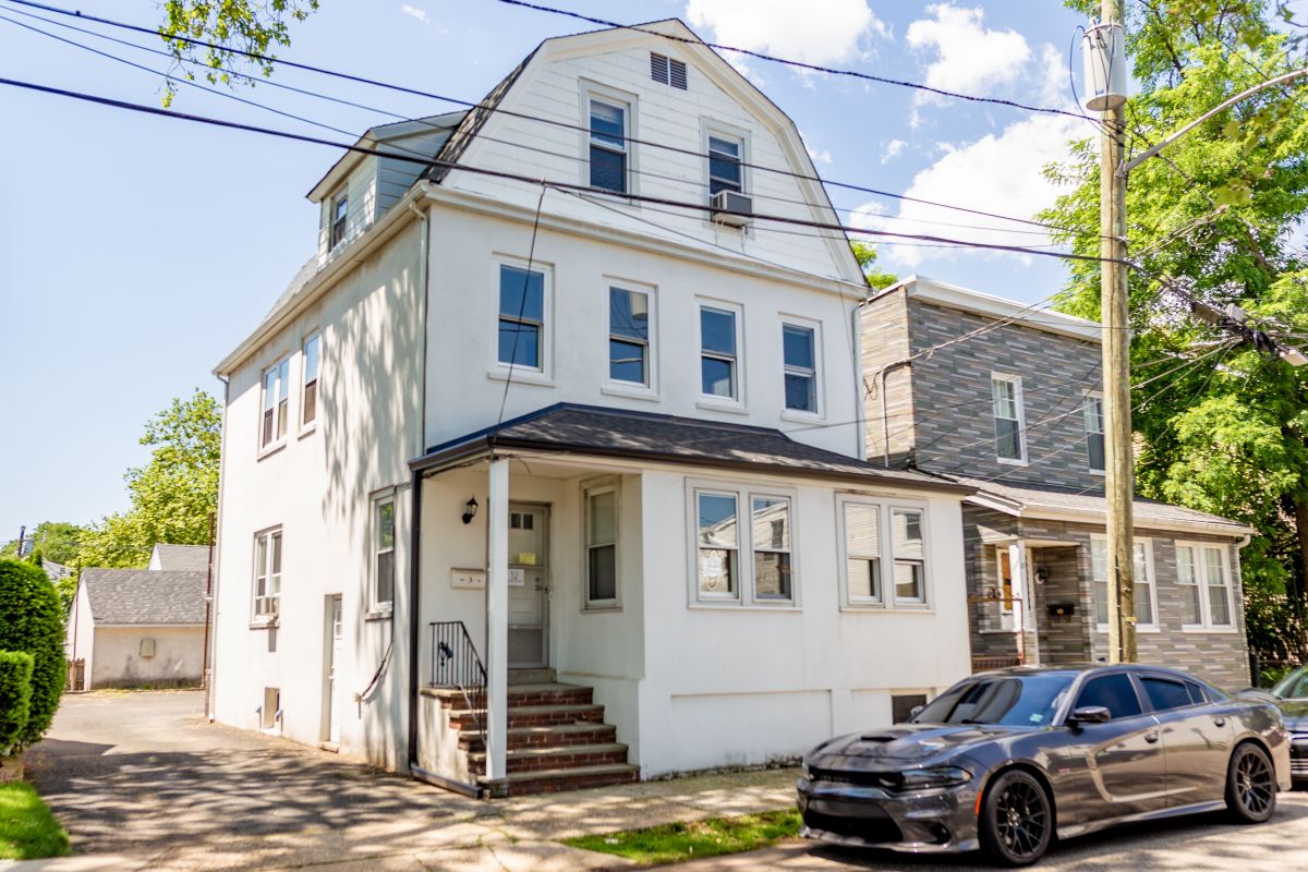 Exterior view of the newly renovated property at 32 Oakwood Avenue in Bloomfield showing a 3 quarter view of the front and driveway side of the house